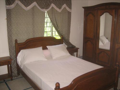 莫罗尼Farida Lodge的一间卧室配有木床和镜子