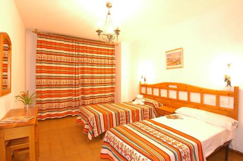 阿尔姆尼卡Bertur Tao的酒店客房设有两张床和窗户。