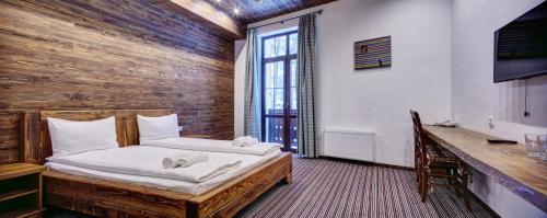 布留霍维奇施帕斯特酒店的一间卧室配有一张木墙床