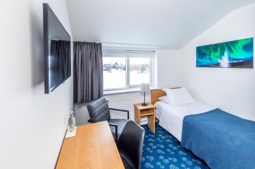 Haukadalur盖锡尔利特里酒店的配有一张床、一张桌子和一张桌子的酒店客房