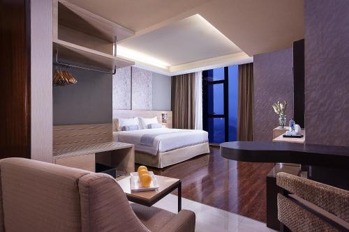 日惹Harper Malioboro Yogyakarta by ASTON的配有一张床和一张书桌的酒店客房