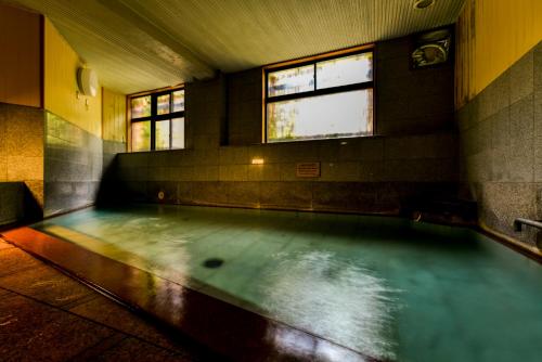 米泽市高宫山川旅馆的一个带两个窗户的房间的水池