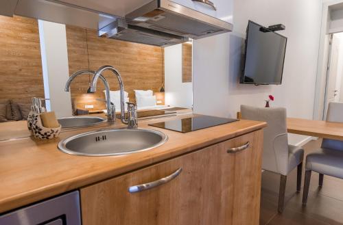 第比利斯Luxury Apartments on Central Avenue的带水槽的厨房、书桌和电视