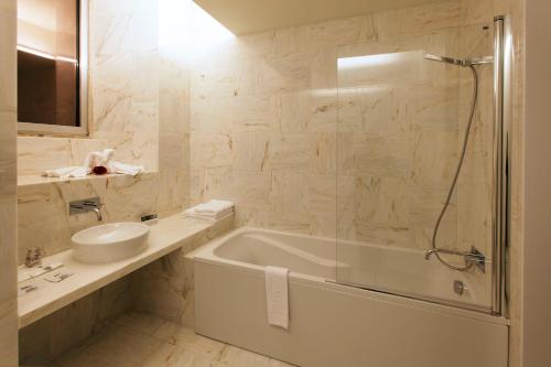 佩内拉HD|杜埃西塔尼亚设计酒店的带浴缸、水槽和镜子的浴室