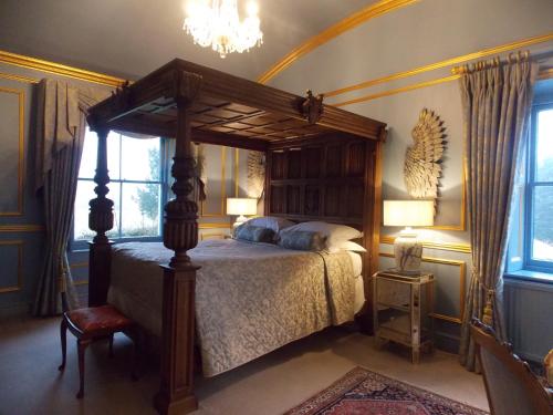 拉文纳姆Rectory Manor的一间卧室配有一张天蓬床和吊灯。