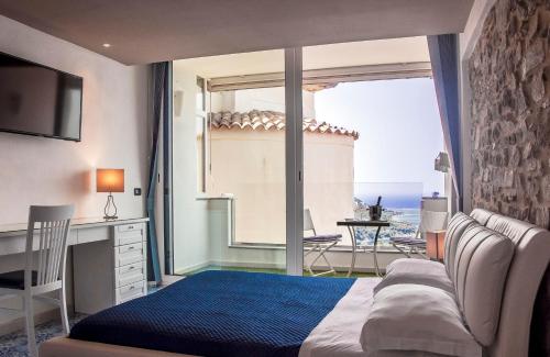 卡斯特拉巴特迪珀卡塔玛拉酒店的一间卧室配有一张床,享有海景