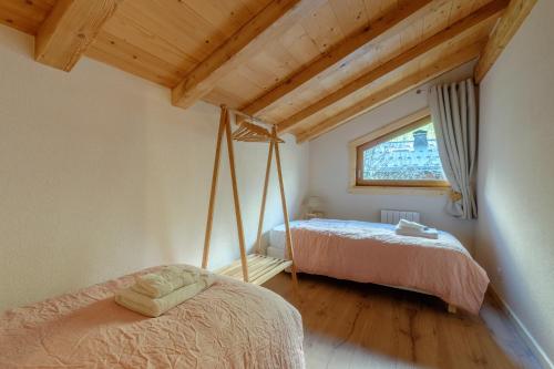 夏蒙尼-勃朗峰Le Chalet de l'Ours Blanc的一间卧室设有两张床和窗户。