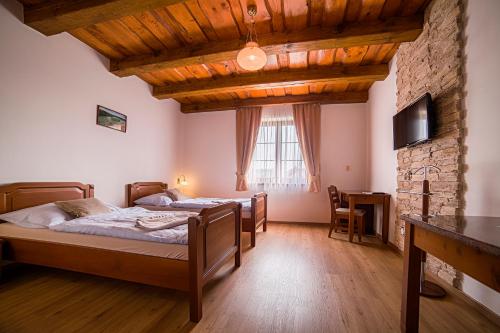 Střítež特里维泽齐酒店的一间卧室设有两张床和石墙