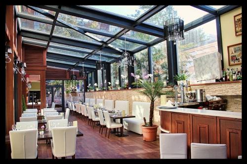 布泽乌艺术酒店的一间设有白色桌椅的餐厅和一间酒吧