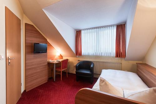 纽伦堡纽恩伯格特里特酒店的配有一张床和一张书桌的酒店客房