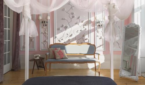 波尔图Boavista Eco-Luxury House的一间卧室设有蓝色椅子和粉红色的墙壁
