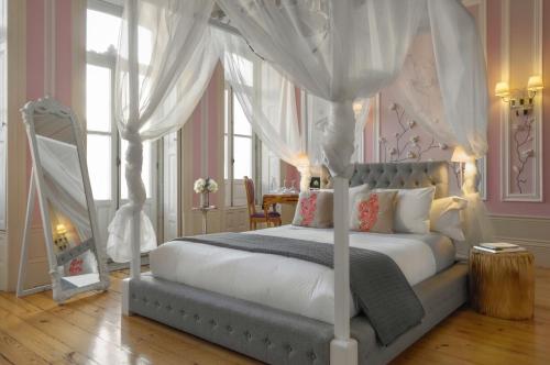 波尔图Boavista Eco-Luxury House的卧室配有带窗帘的白色天蓬床