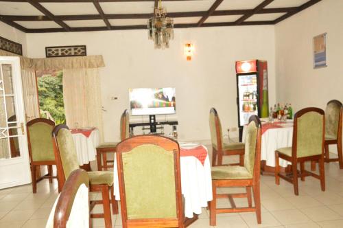 吉塞尼Ubumwe Hotel的一间带桌椅的用餐室
