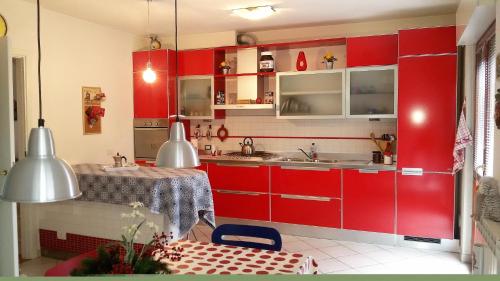 锡耶纳Casa Arcobaleno的红色的厨房设有水槽和桌子