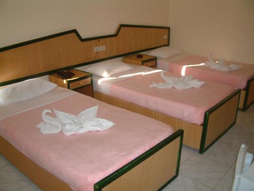 赫尔格达赫尔格达戴安娜酒店的一间设有三张床的房间,里面装有白色的花