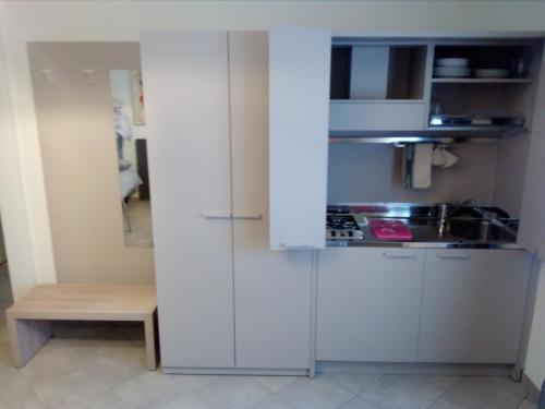 博尔索-德尔格拉帕Salvia e Timo Rooms的小厨房配有白色橱柜和桌子