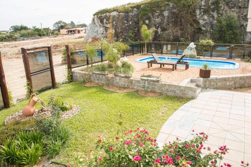 CristalPousada Pedra Bonita的一个带游泳池、长凳和鲜花的花园