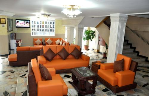 比亚维森西奥Hotel el Caimito的客厅配有橙色家具和楼梯