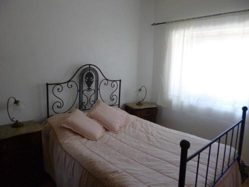 ArneiroCasa de Santana的一间卧室配有一张带白色床单的床和一扇窗户。