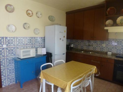 ArneiroCasa de Santana的厨房配有桌子和白色冰箱。