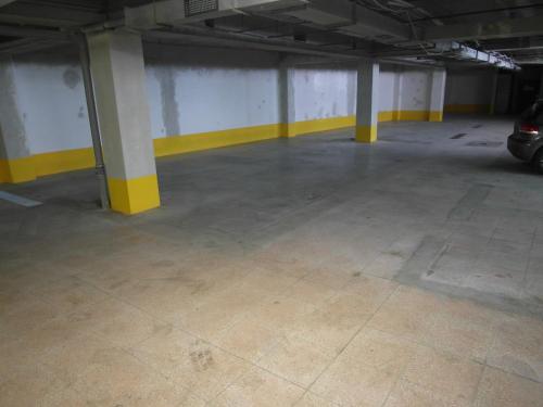 布尔诺Apartments Kopečná with parking的一个空的停车场,有黄色和白色的柱子