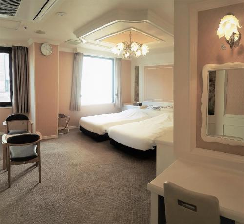 东京新大久保皇家酒店的酒店客房,配有两张床和椅子