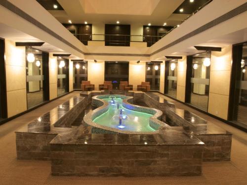 艾哈迈达巴德坎贝格朗德酒店的大楼中央带游泳池的大堂