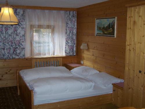 施图拜河谷新施蒂夫特Pension Holzknechthof am See的一间卧室设有两张床和窗户。