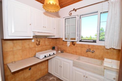 瓦西里科斯Fiore Hill Sea View Studios的厨房配有白色橱柜、水槽和窗户。