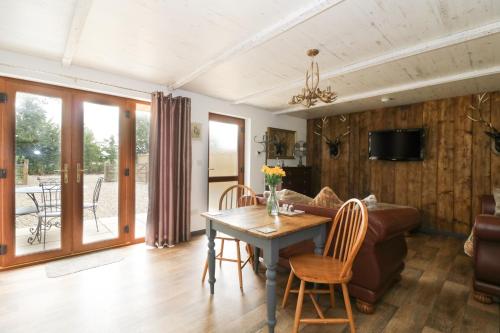 霍舍姆圣斐德Foxley Wood Cottage的客厅配有桌子和沙发