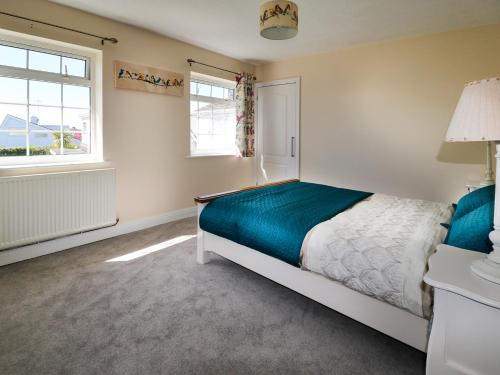 LlandegfanAnglesey White Haven的一间卧室设有一张床和两个窗户。