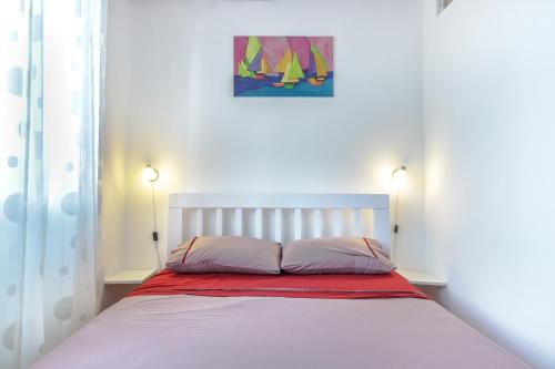 波德戈里察Charming City Center的一张带两个枕头的床和墙上的绘画