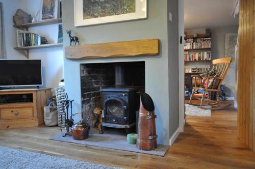 克利尔威尔Foxglove Cottage的带壁炉的客厅配有炉灶