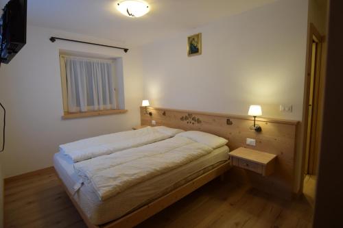 坎皮泰洛迪法萨Vajolet的一间小卧室,配有一张床和一张桌子