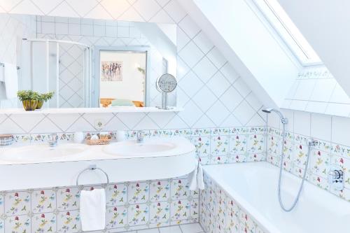 克勒希Hotel Garni Schöne Aussichten的浴室配有两个盥洗盆和浴缸。