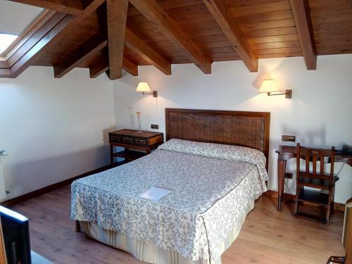 Quintana de Llanes阿尔达马高尔夫球酒店的卧室配有1张床、1张桌子和1把椅子