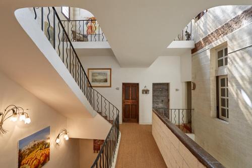 阿维尼翁新城阿特利亚酒店的房屋内有 ⁇ 的楼梯,拥有白色的墙壁和木制天花板
