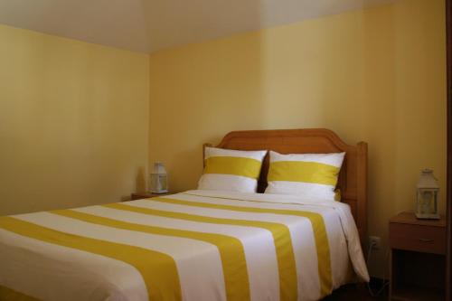 滨海保尔One Love Maktub的一间卧室配有一张黄色和白色条纹的大床
