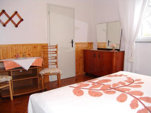克尔克Sobe Bozica的一间卧室配有一张床、一张书桌和一面镜子