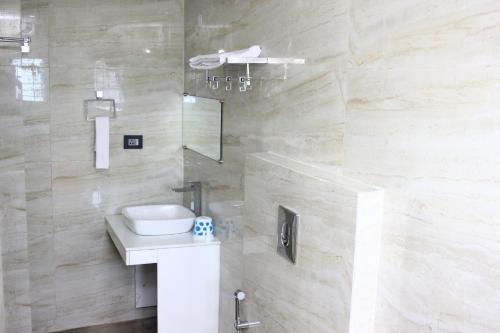 古瓦哈提Hotel Shreemoyee Inn - Kamakhya Temple的浴室配有卫生间、盥洗盆和淋浴。