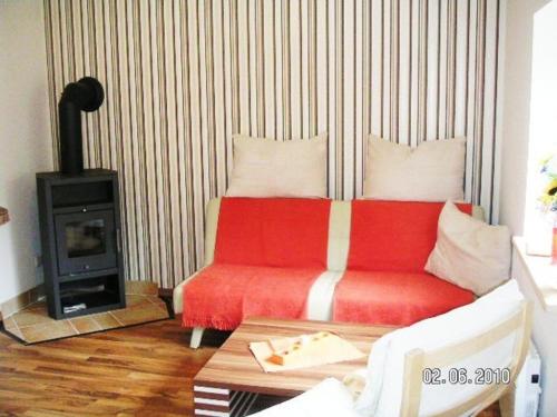 卡尔斯哈根FH Charlottchen_WEIG的客厅配有红色沙发和炉灶