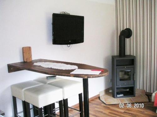 卡尔斯哈根FH Charlottchen_WEIG的客房设有桌子、电视和炉灶。