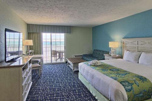 特拉弗斯城苏格海滩度假村酒店的酒店客房设有一张大床和一个阳台。
