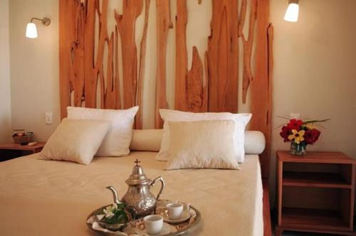 卡诺格布拉达Pousada Dona Flor的一间卧室配有一张带木制床头板的床