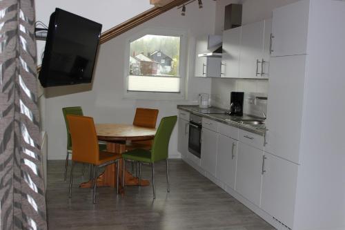 兰河畔马尔堡Ferienwohnung in Marburg/Wehrda的厨房配有桌椅和电视。