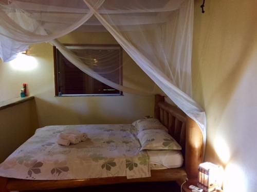 卡纳维埃拉斯巴伊亚多美居酒店的一间卧室配有一张天蓬床和窗户