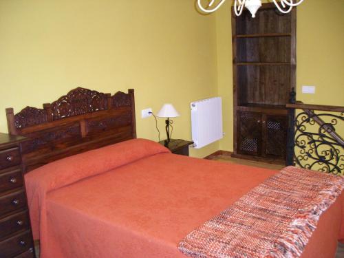 努埃瓦德兰斯Apartamento Sopiedra的一间卧室配有一张带橙色床罩的大床