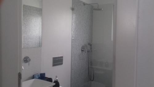 塔维拉Tavira independent suite with Pool at Casa Reflexos的带淋浴和盥洗盆的白色浴室