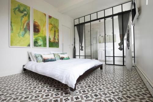 巴黎MONTMARTRE ROMANTIC - chambres d'hôtes de charme à Montmartre - Paris的一间卧室设有一张大床和一个大窗户