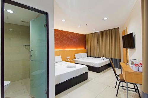 普崇招牌酒店@蒲种瑟迪亚步行区的酒店客房设有两张床和淋浴。
